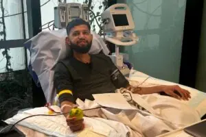 Aadil, a stem cell donor of South Asian heritage, smiling while donating stem cells in hospital