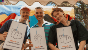 Three people smiling as they show how quick and easy it is to join the stem cell donor registry