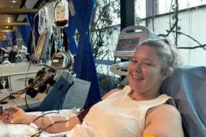 Abbey smiling while donating stem cells through her blood in hospital