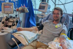 Young man donating stem cells through peripheral blood stem cell collection