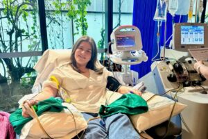 Young woman donating stem cells through an apheresis machine in hospital