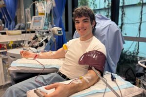 Oscar smiling during his stem cell donation with cannulas in both arms