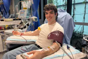Oscar smiling during his stem cell donation with cannulas in both arms